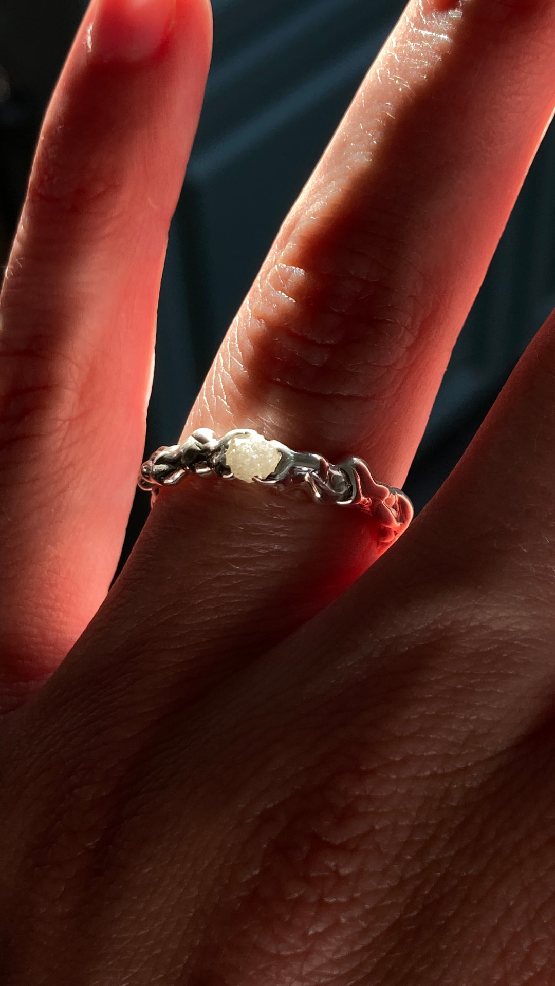 Bespoke silver ring with raw diamond worn on hand